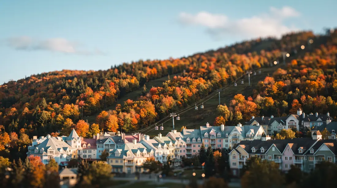 Pastel resort village below a ski hill in autumn