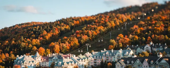 Pastel resort village below a ski hill in autumn